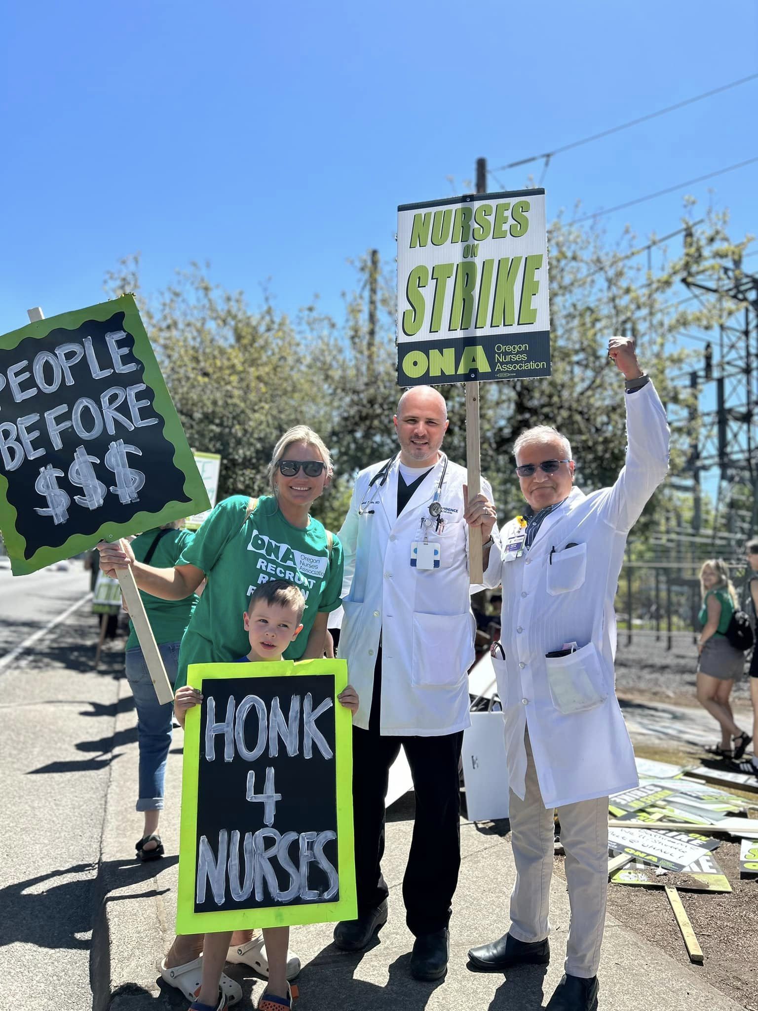 Hospitalists holding picket signs with union sibling nurses